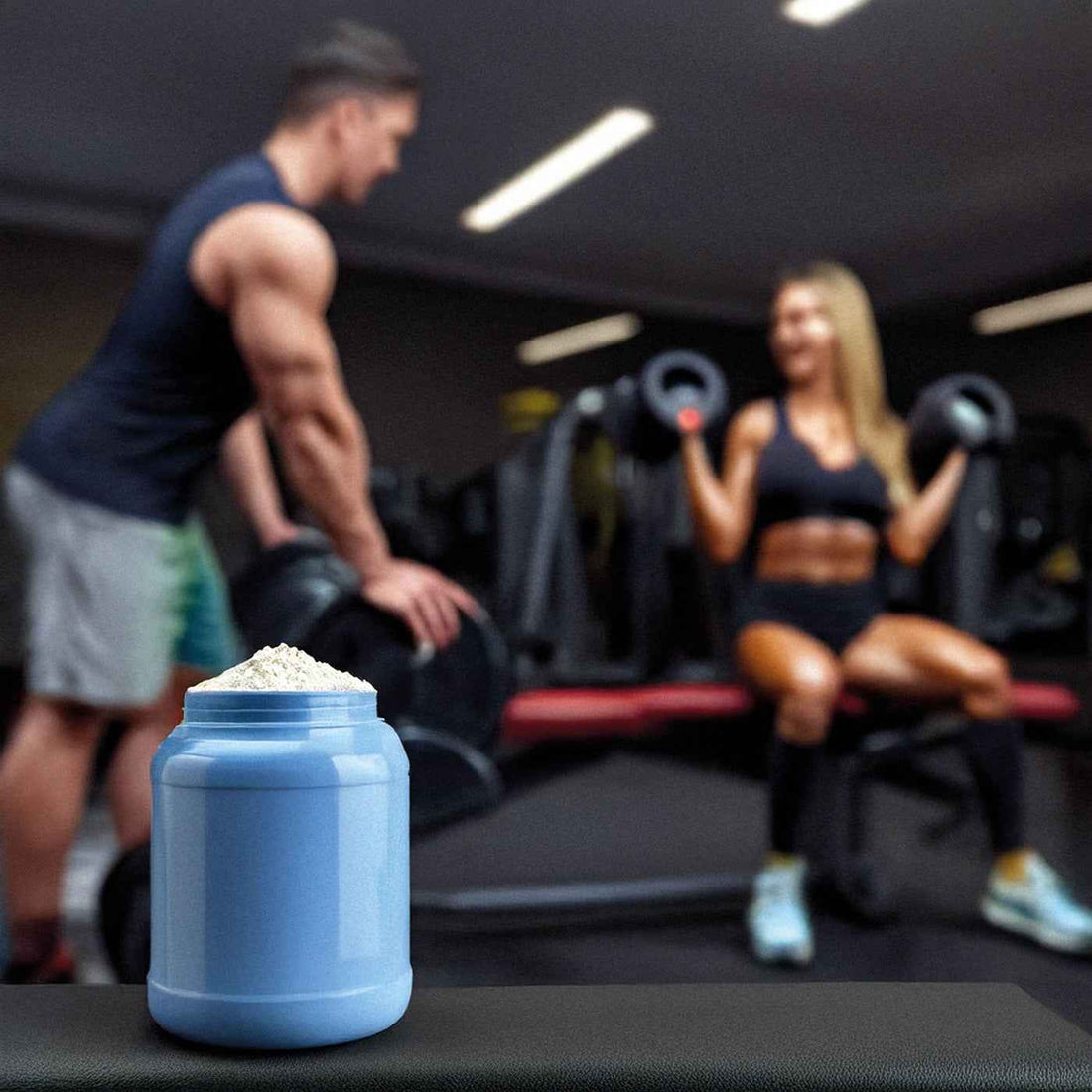 Barattolo di integratore proteico in polvere in palestra con atleti sullo sfondo