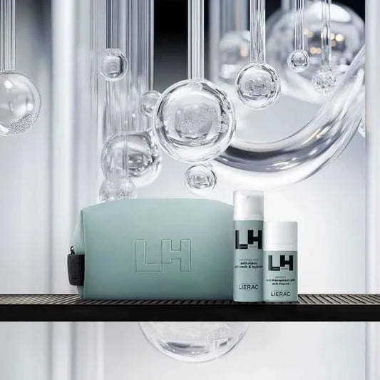Set cosmetici Lierac LH uomo con beauty bag azzurra, flaconi su sfondo moderno con bolle trasparenti